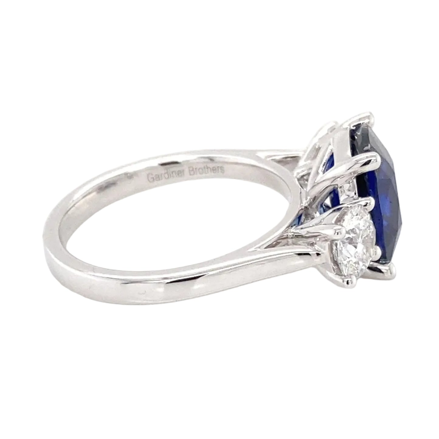 Cushion Shaped Sapphire and round brilliant cut diamond 3 stone ring Gardiner Brothers