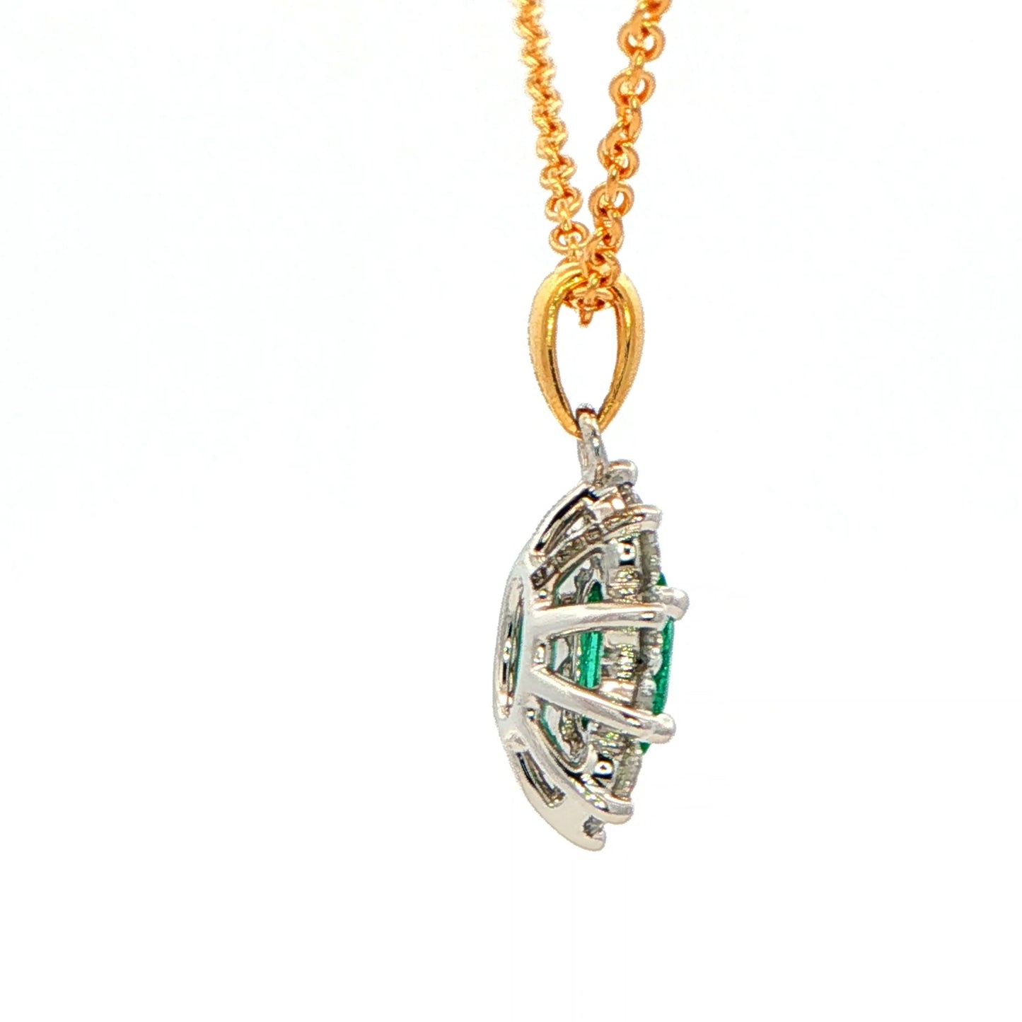 Oval shaped emerald and round brilliant cut diamond cluster style pendant Gardiner Brothers
