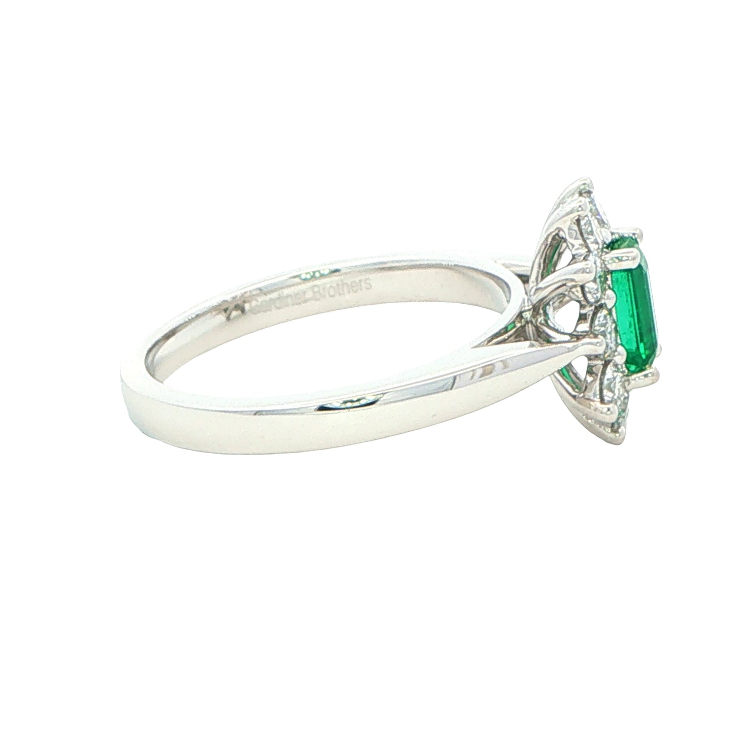Octagonal shaped emerald and round brilliant cut diamond cluster style ring