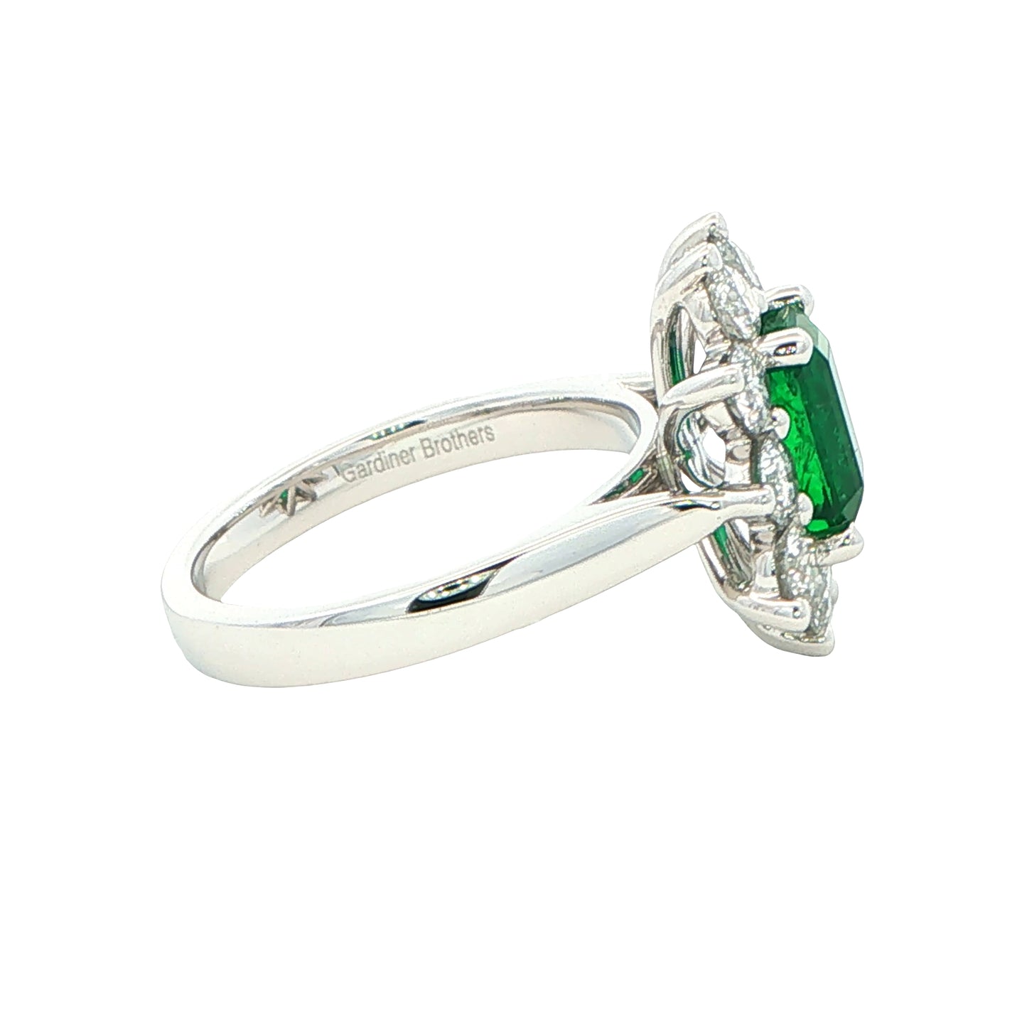 Octagonal shaped emerald and round brilliant cut diamond cluster style ring