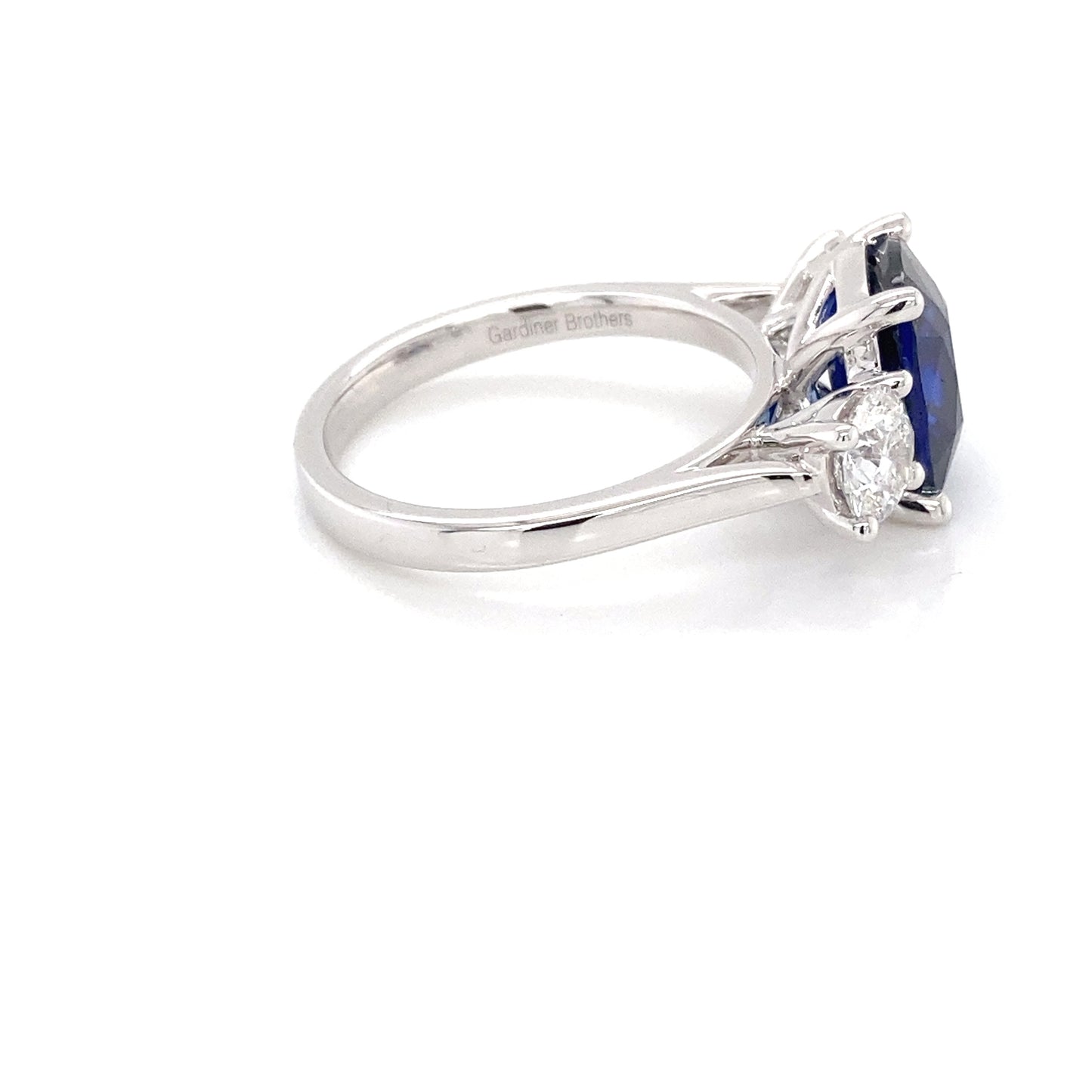 Cushion Shaped Sapphire and round brilliant cut diamond 3 stone ring Gardiner Brothers