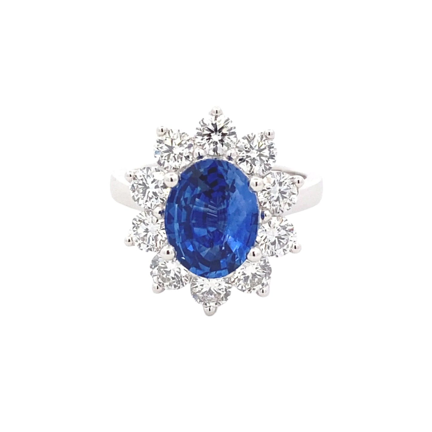 Oval Shaped Sapphire and round brilliant cut diamond traditional cluster ring Gardiner Brothers