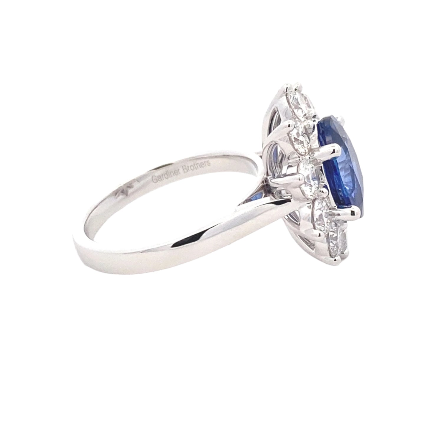 Oval Shaped Sapphire and round brilliant cut diamond traditional cluster ring Gardiner Brothers