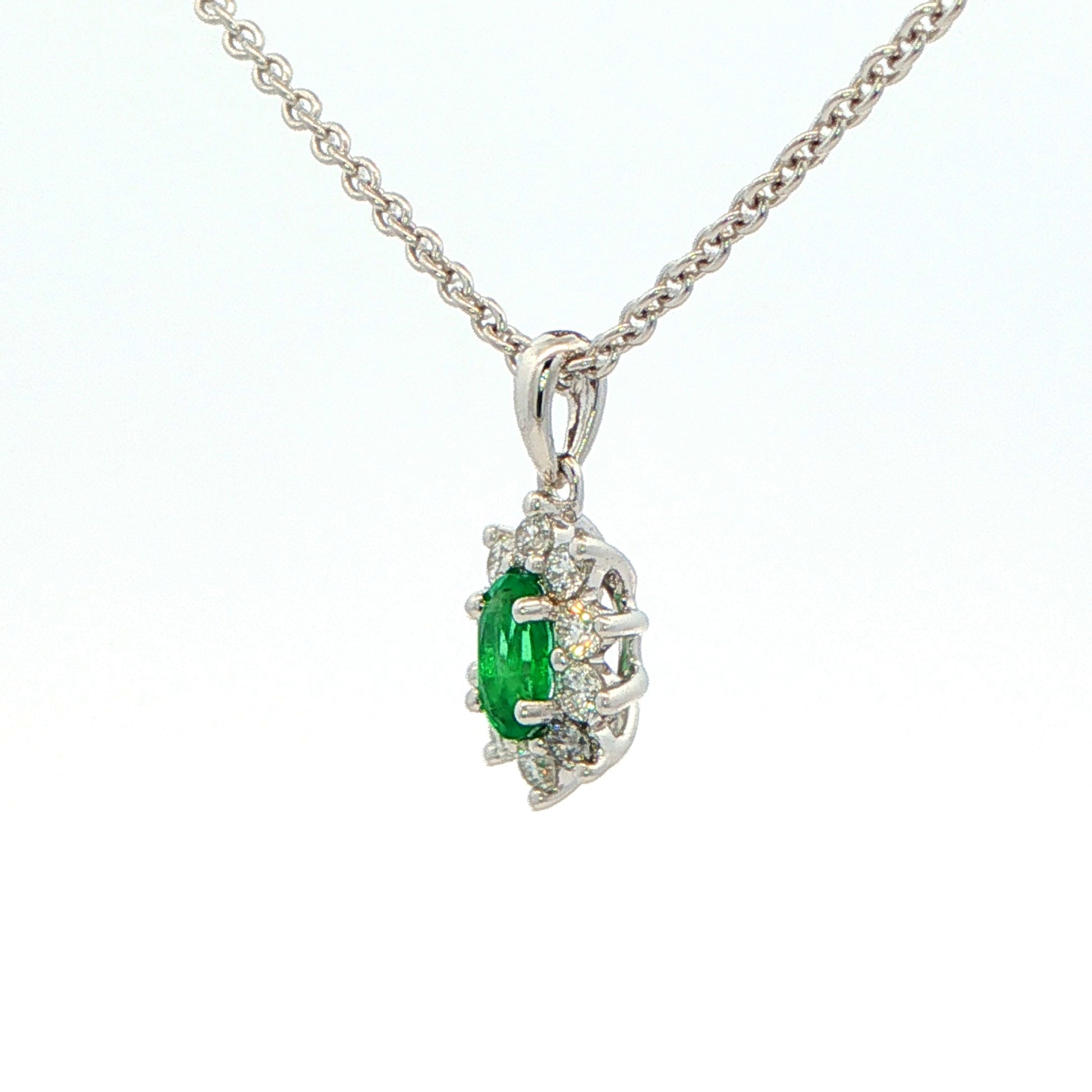 Oval Shaped emerald and round brilliant cut diamond cluster pendant Gardiner Brothers