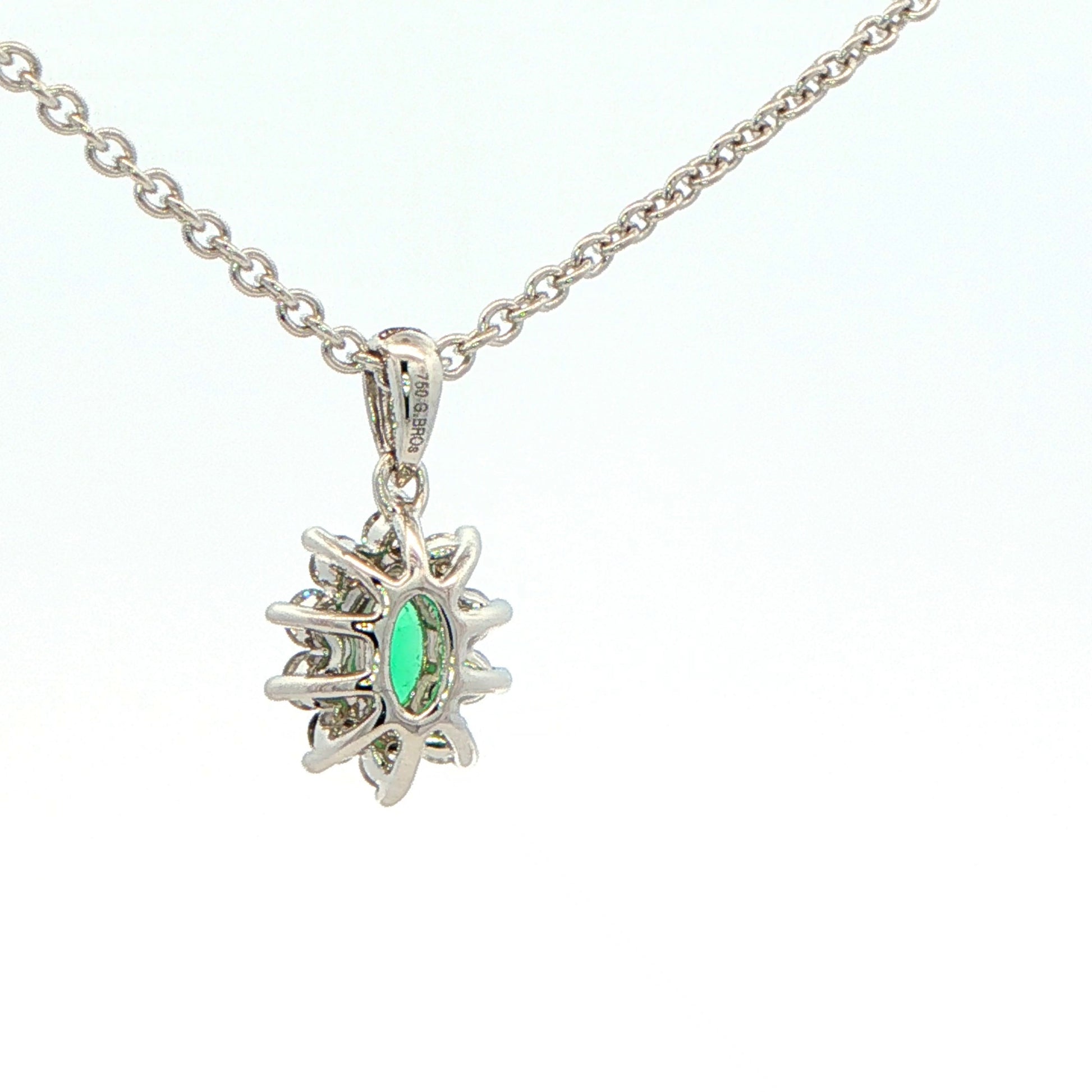 Oval Shaped emerald and round brilliant cut diamond cluster pendant Gardiner Brothers