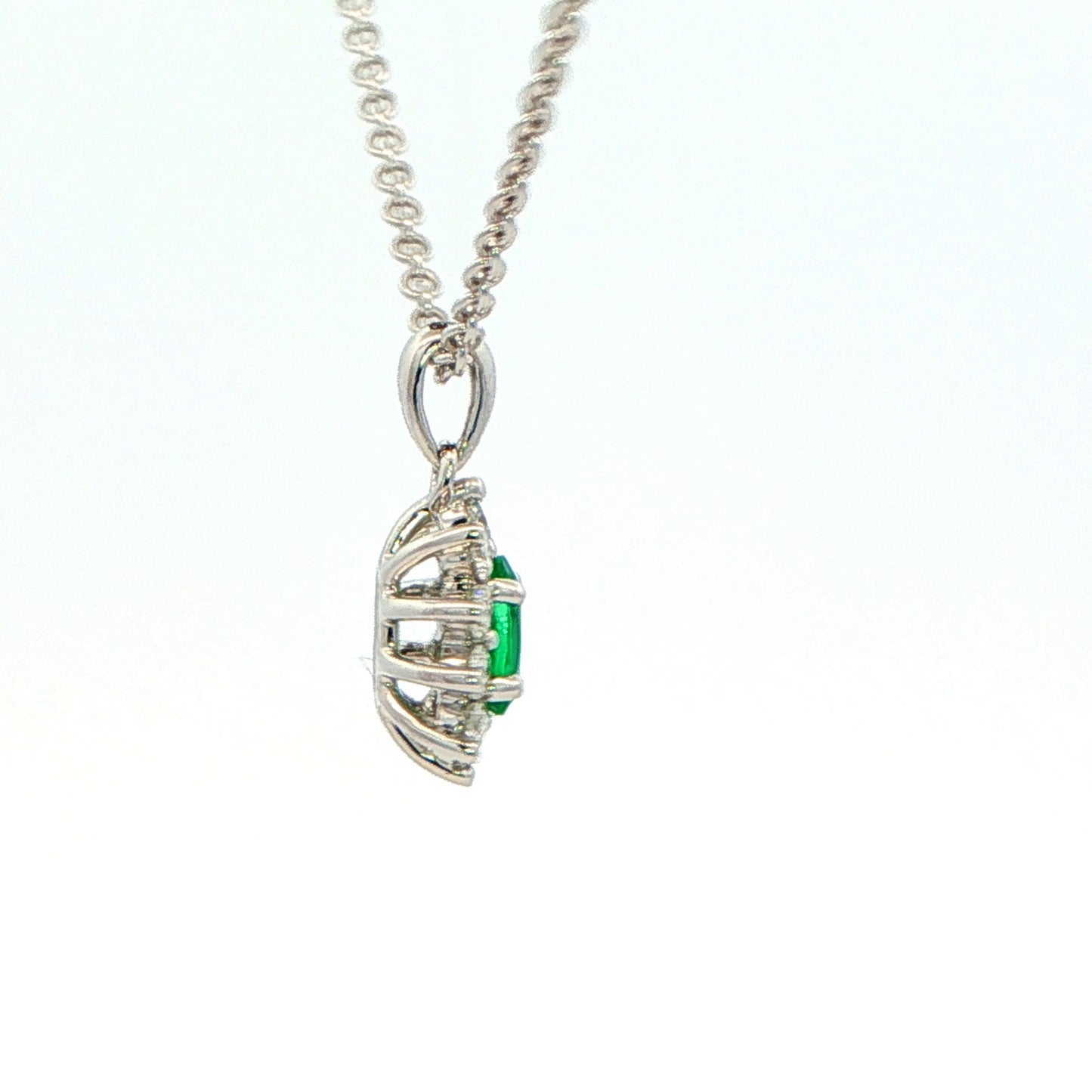 Oval Shaped emerald and round brilliant cut diamond cluster pendant Gardiner Brothers