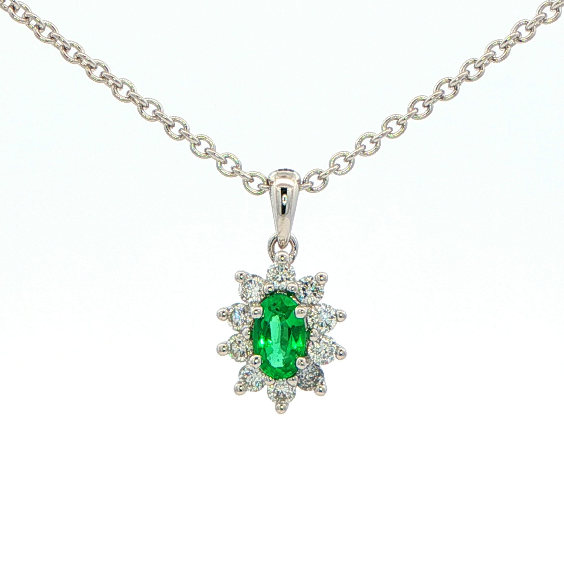 Oval Shaped emerald and round brilliant cut diamond cluster pendant Gardiner Brothers