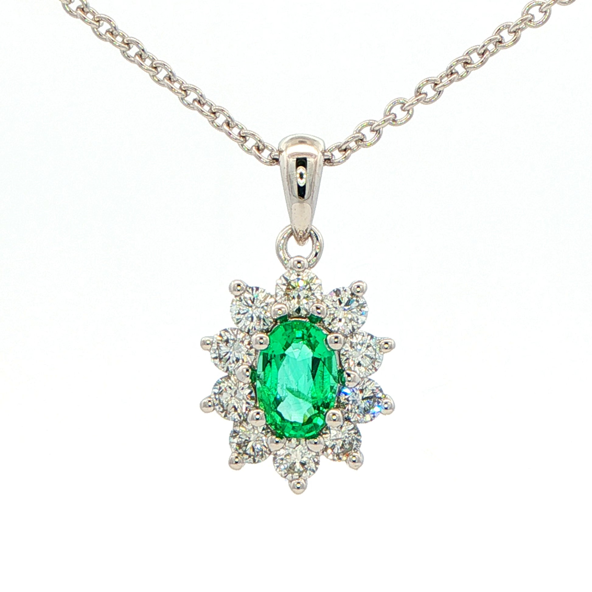 Oval shaped emerald and round brilliant cut diamond cluster pendant Gardiner Brothers