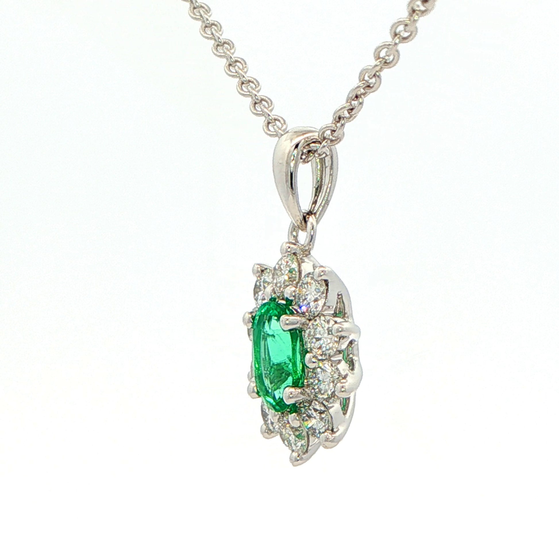 Oval shaped emerald and round brilliant cut diamond cluster pendant Gardiner Brothers