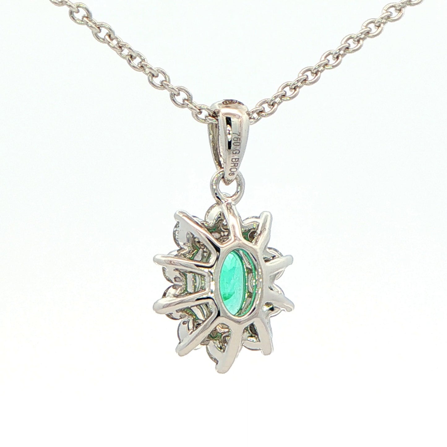 Oval shaped emerald and round brilliant cut diamond cluster pendant Gardiner Brothers