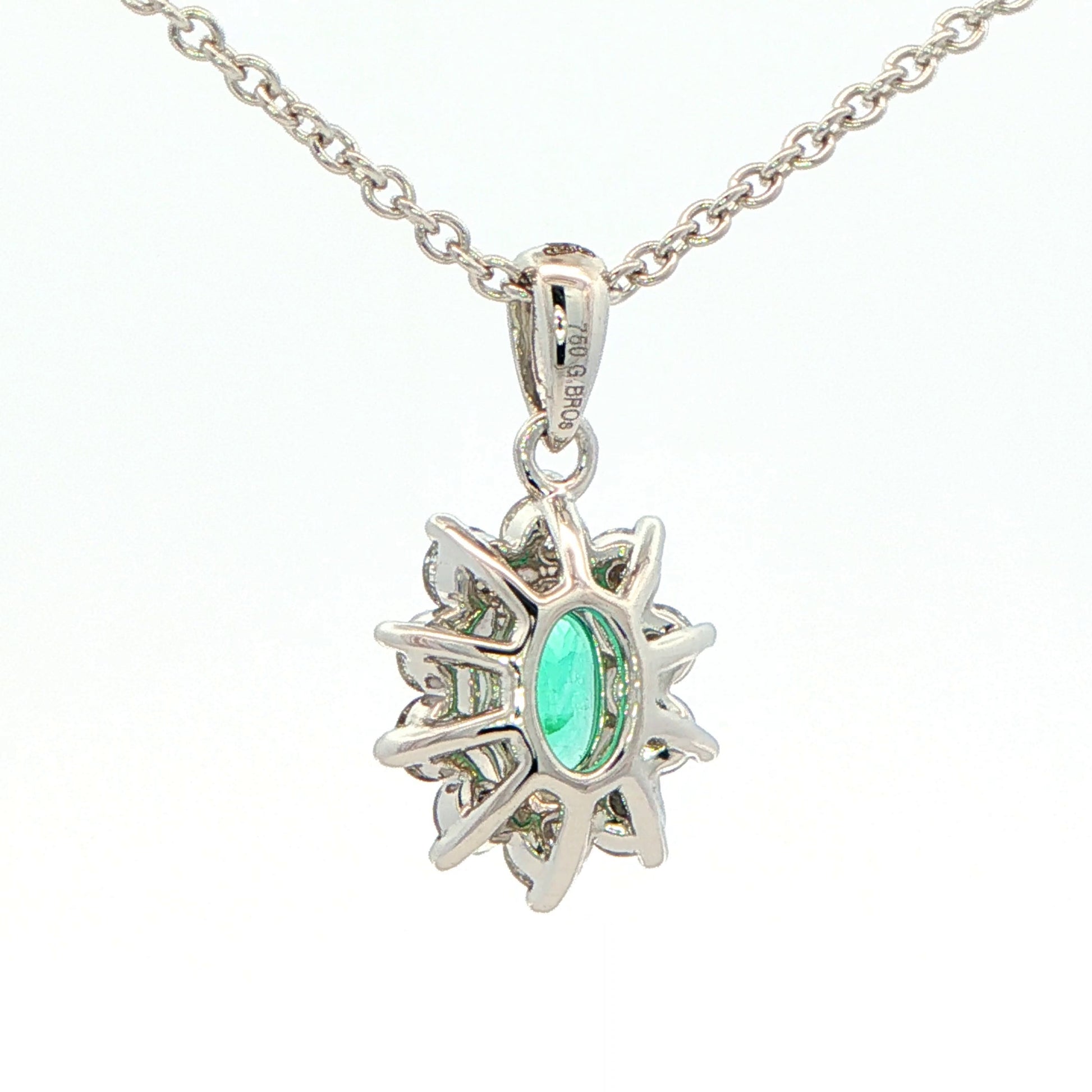 Oval shaped emerald and round brilliant cut diamond cluster pendant Gardiner Brothers