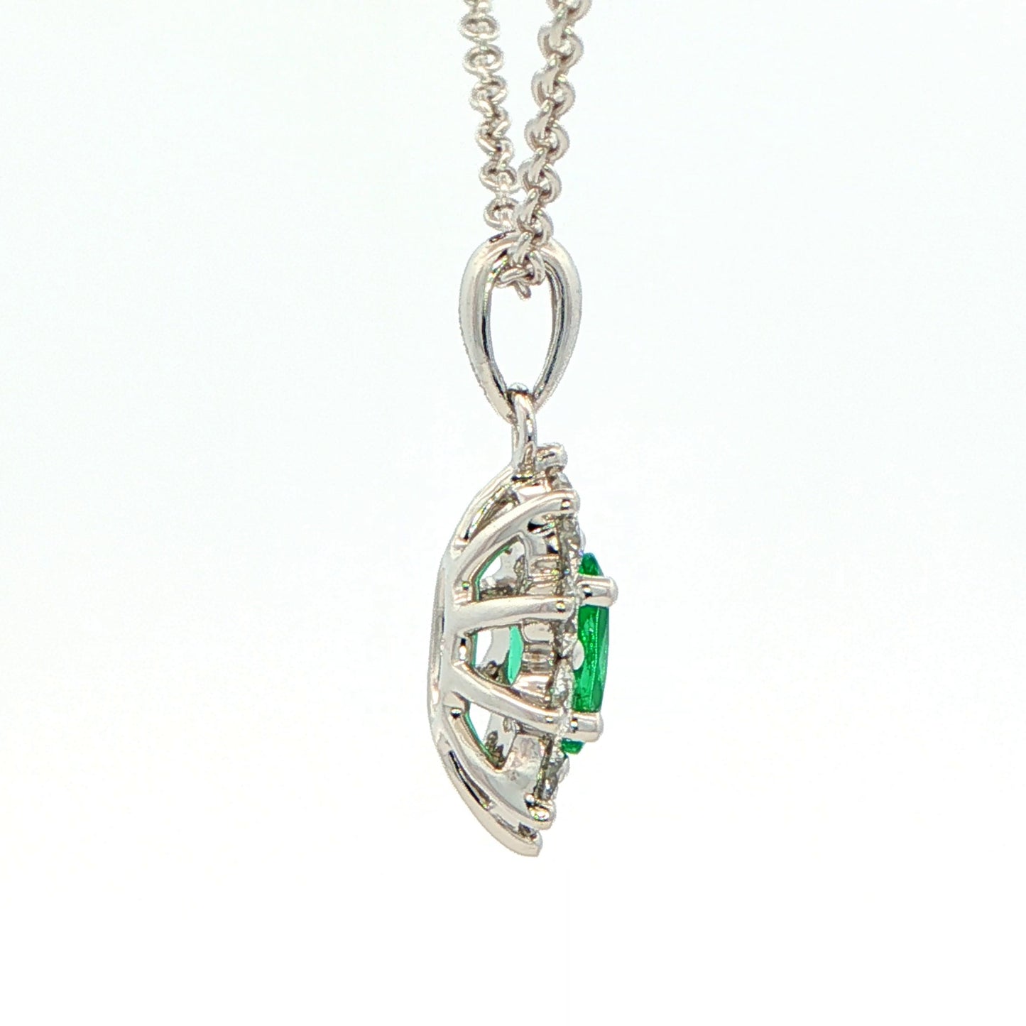 Oval shaped emerald and round brilliant cut diamond cluster pendant Gardiner Brothers