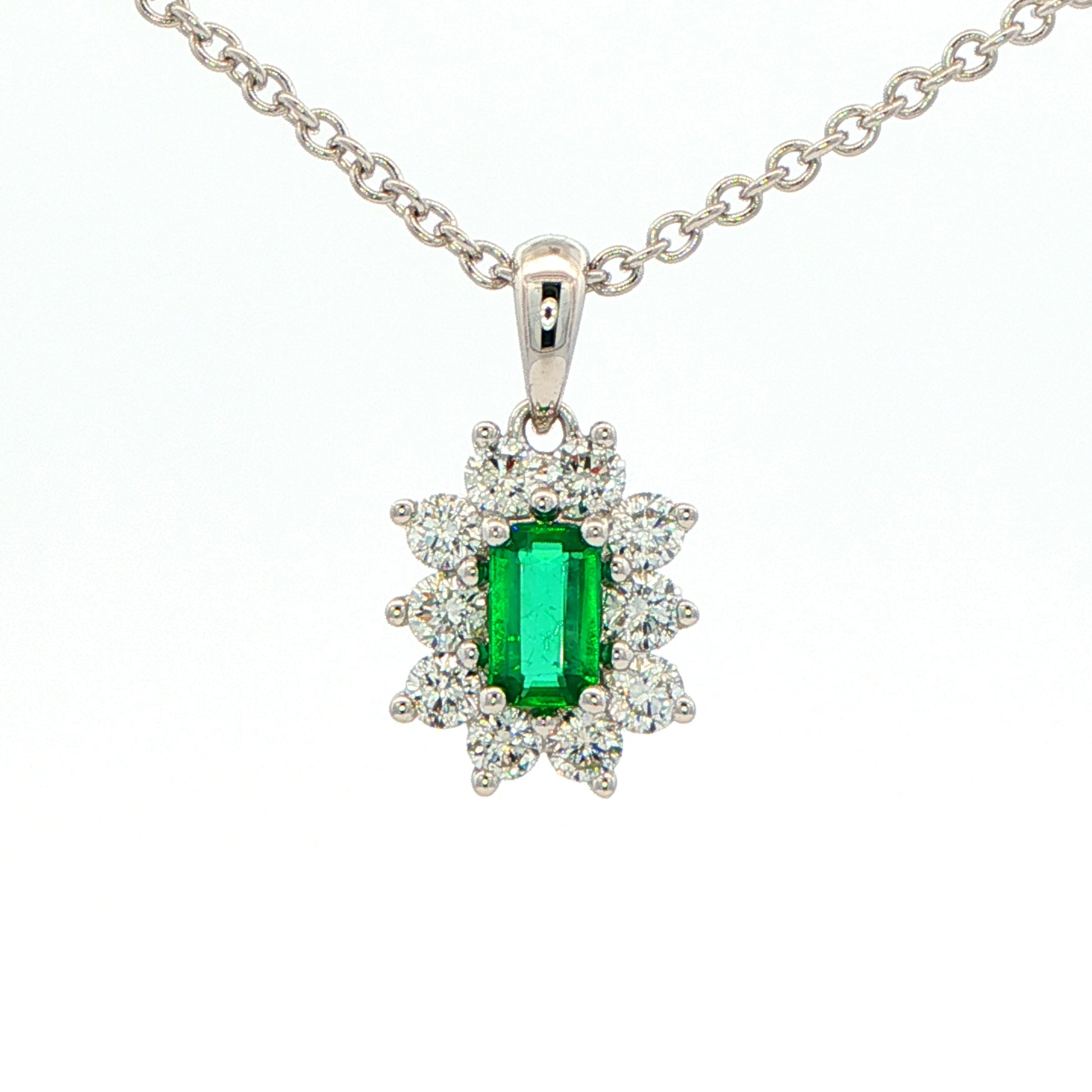 Octagonal shaped emerald and round brilliant cut diamond cluster pendant Gardiner Brothers