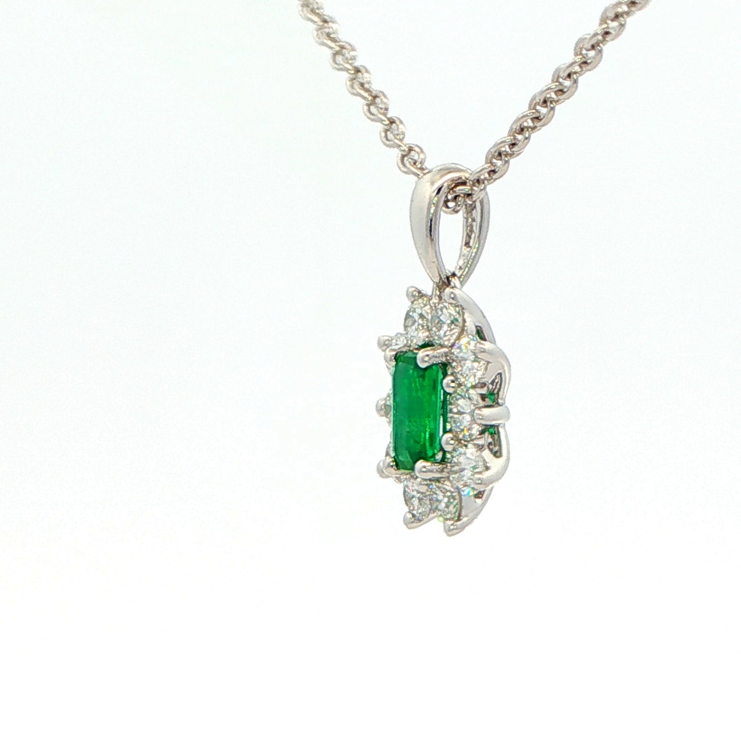 Octagonal shaped emerald and round brilliant cut diamond cluster pendant Gardiner Brothers