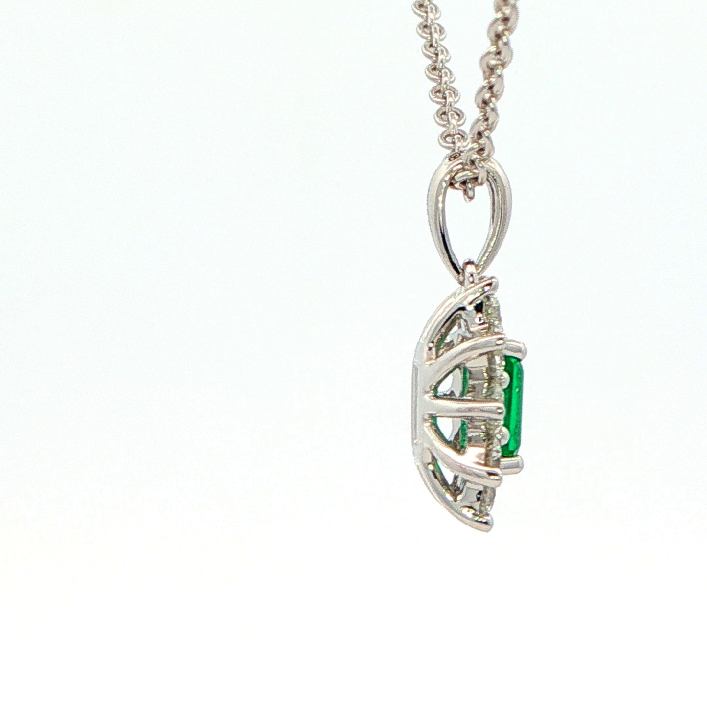Octagonal shaped emerald and round brilliant cut diamond cluster pendant Gardiner Brothers