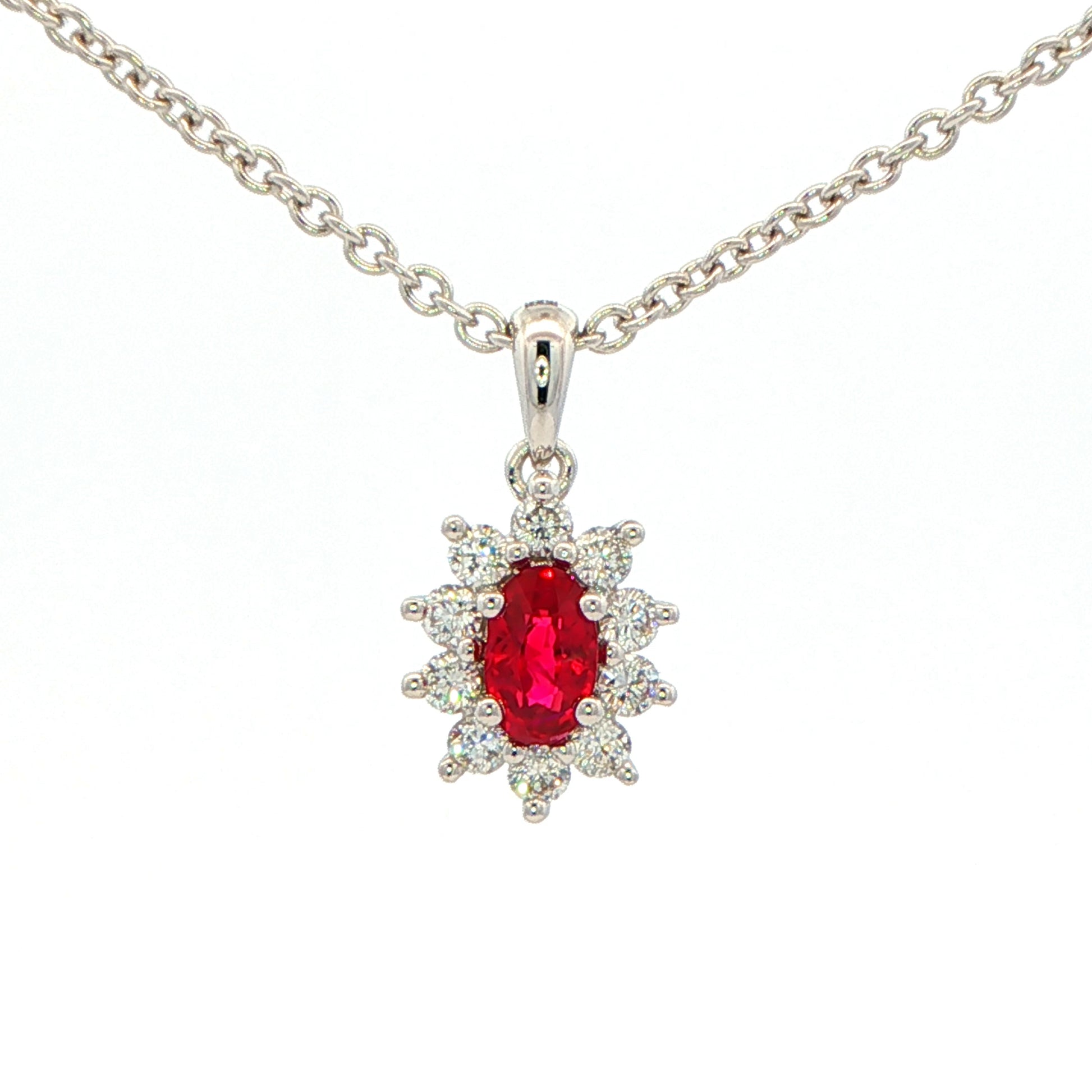 Oval shaped ruby and round brilliant cut diamond cluster style pendant Gardiner Brothers
