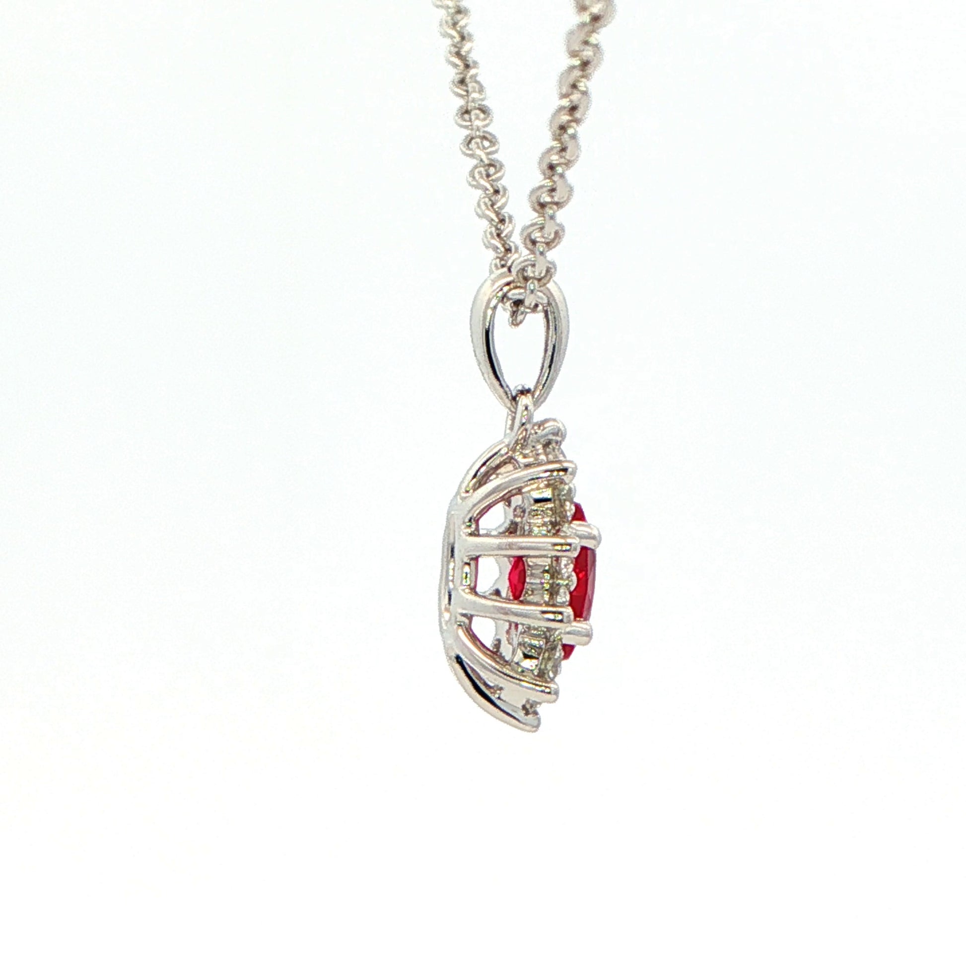 Oval shaped ruby and round brilliant cut diamond cluster style pendant Gardiner Brothers