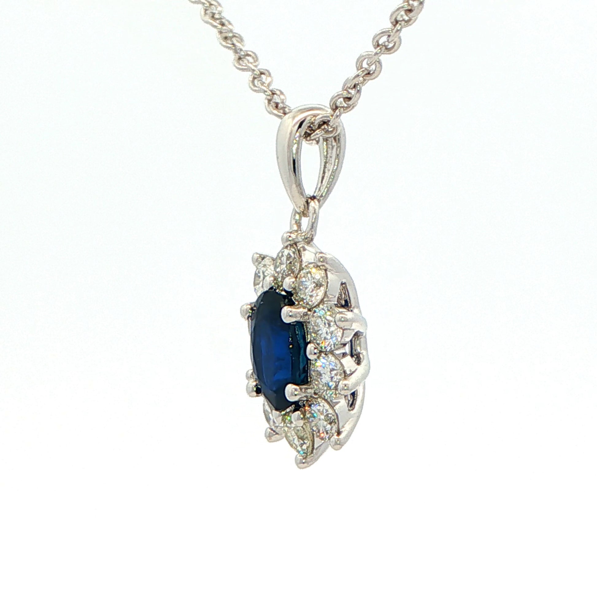 Oval shaped sapphire and round brilliant cut diamond cluster style pendant Gardiner Brothers