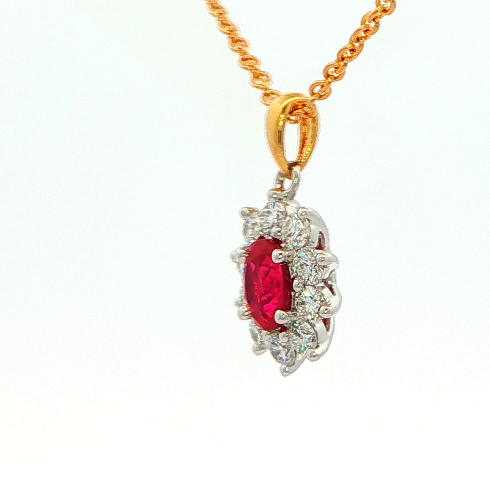 Oval shaped ruby and round brilliant cut diamond cluster style pendant Gardiner Brothers