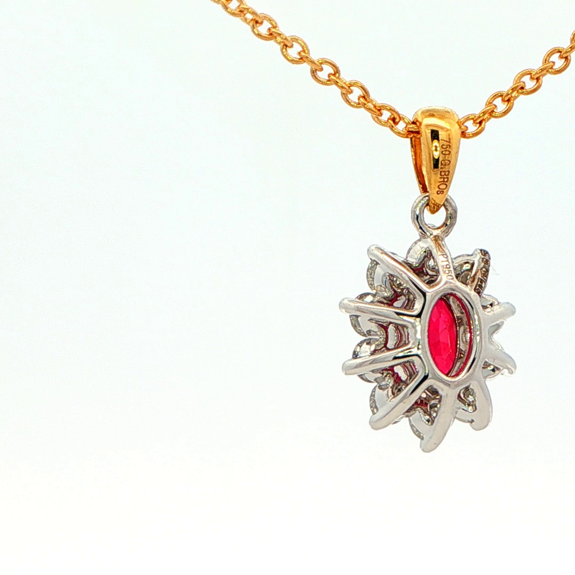 Oval shaped ruby and round brilliant cut diamond cluster style pendant Gardiner Brothers