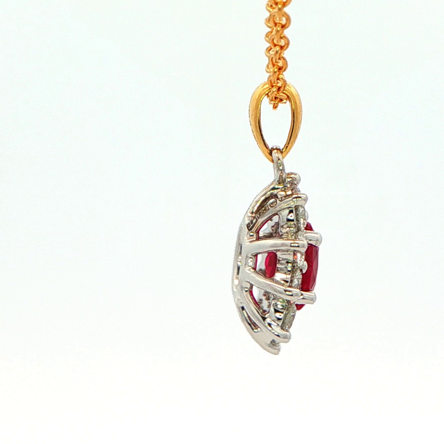 Oval shaped ruby and round brilliant cut diamond cluster style pendant Gardiner Brothers