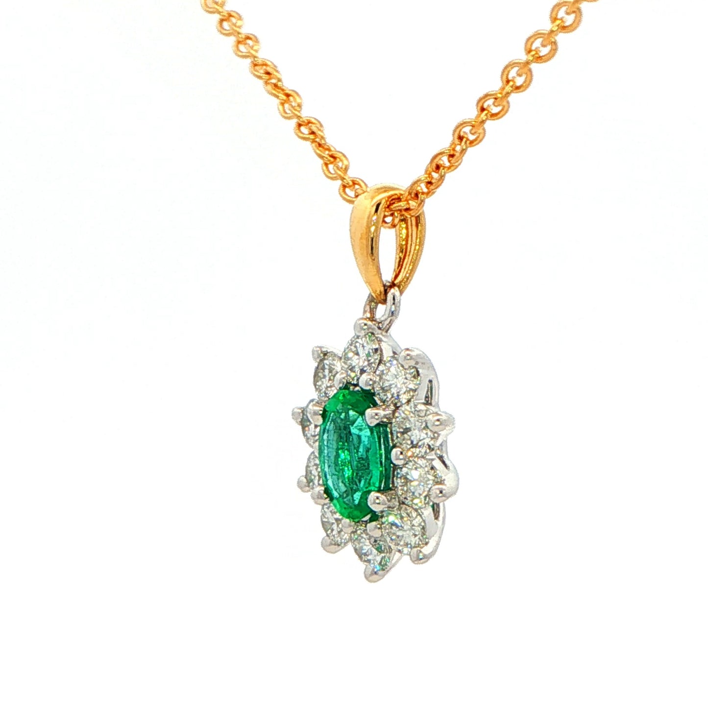 Oval shaped emerald and round brilliant cut diamond cluster style pendant Gardiner Brothers