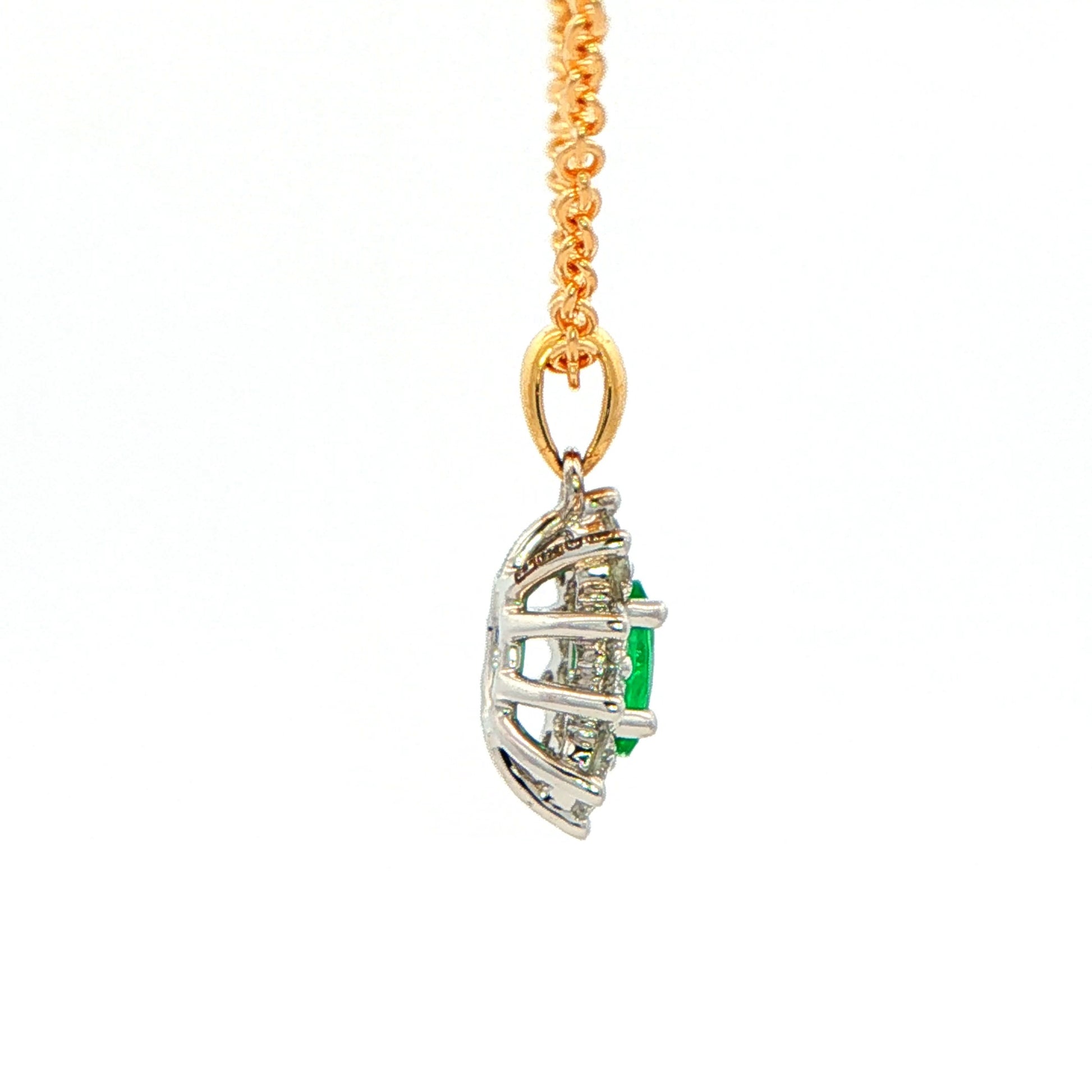Oval shaped emerald and round brilliant cut diamond cluster style pendant Gardiner Brothers