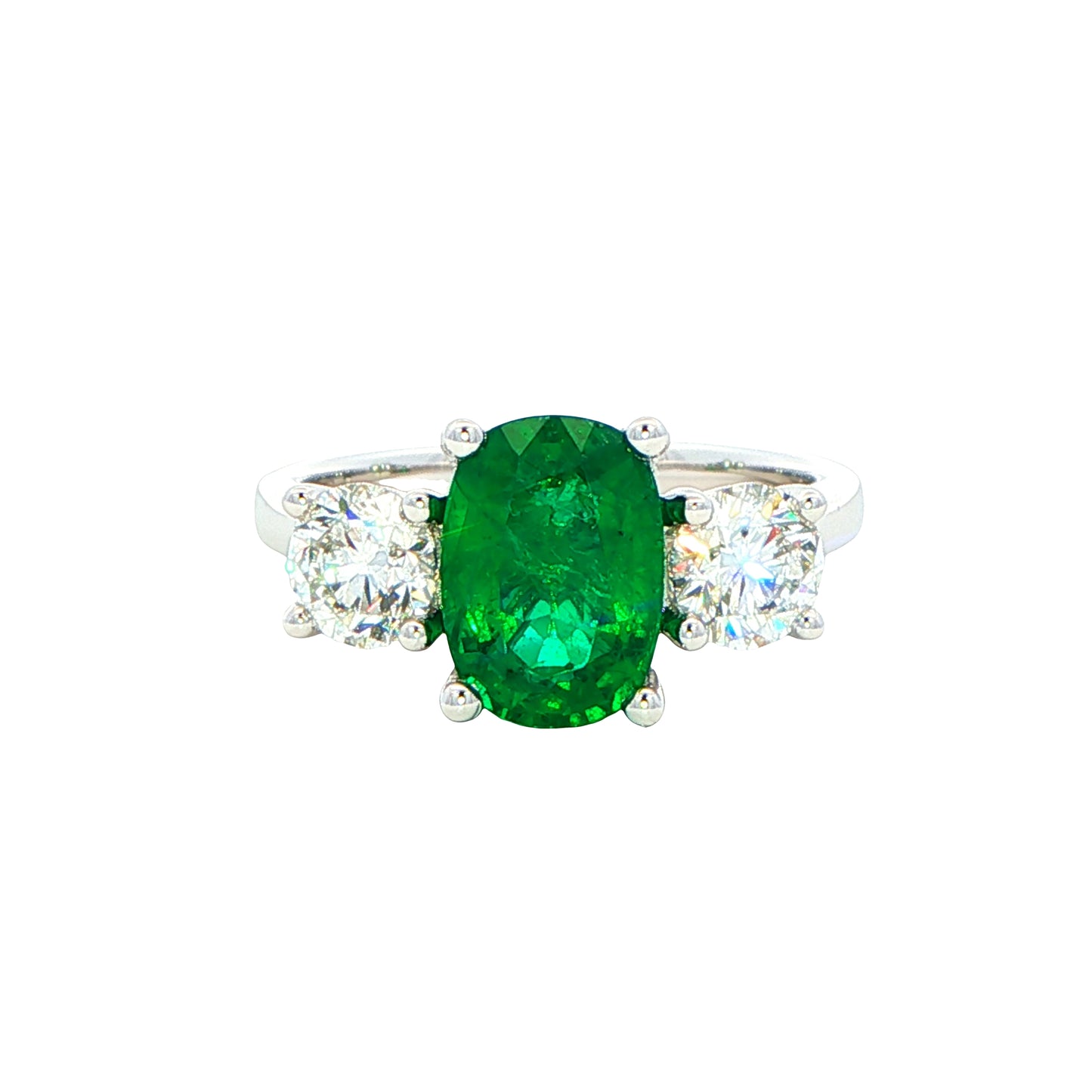 Cushion shaped emerald and round brilliant cut diamond 3 stone ring Gardiner Brothers