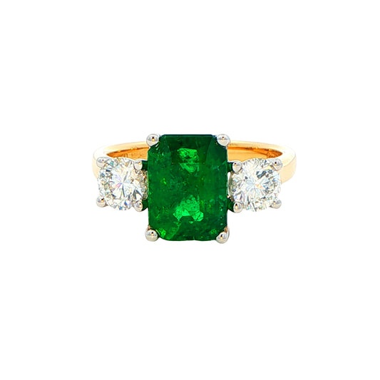 Octagonal shaped emerald and round brilliant cut diamond 3 stone ring Gardiner Brothers