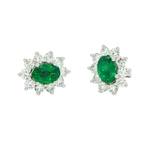 Oval shaped emerald and round brilliant cut diamond cluster style earrings