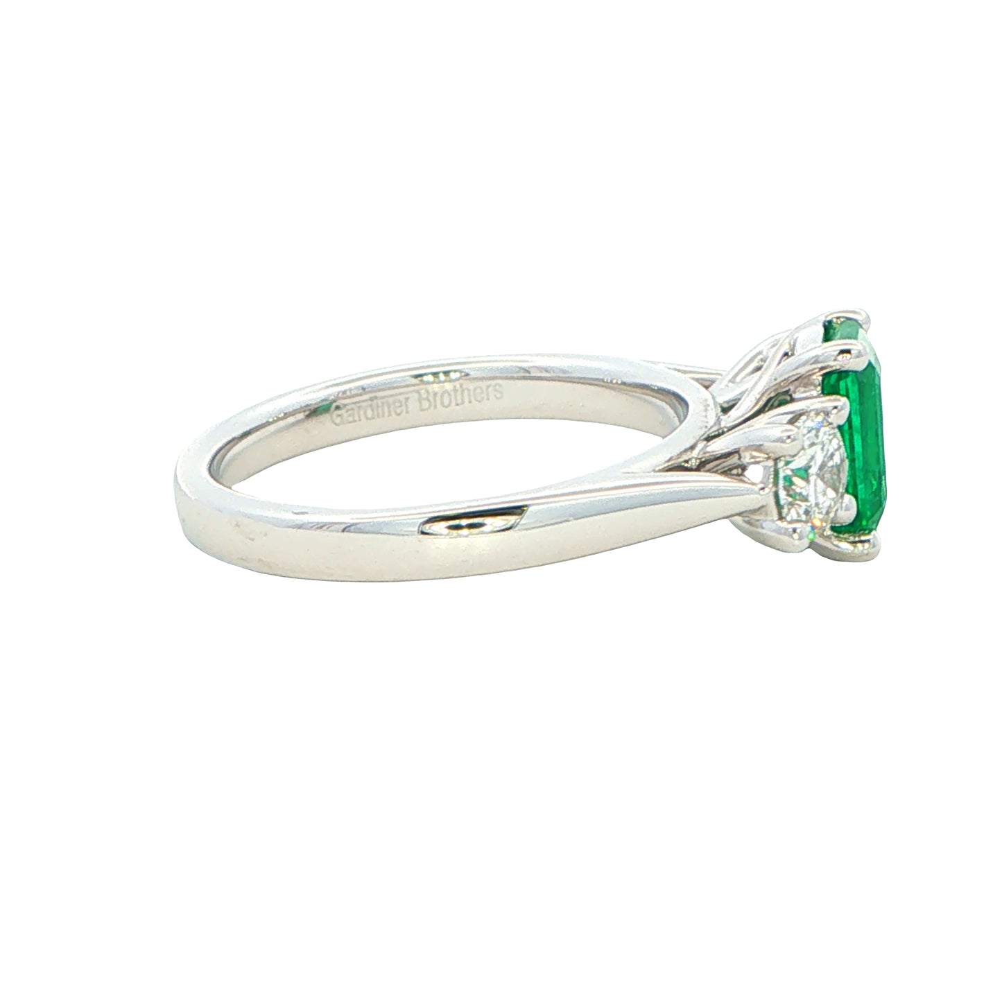 Octagonal shaped emerald and round brilliant cut diamond 3 stone ring Gardiner Brothers